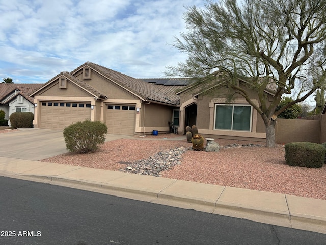 view of front of property featuring a garage and solar panels