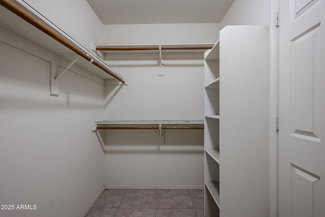 walk in closet with light tile patterned floors