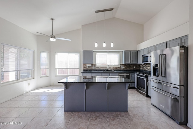 kitchen with sink, hanging light fixtures, a center island, light tile patterned floors, and stainless steel appliances