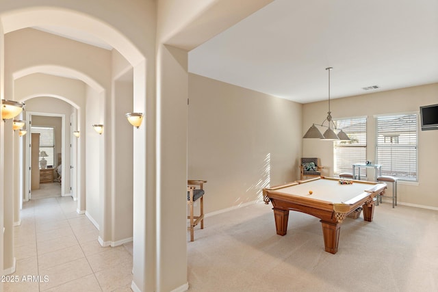 rec room with light tile patterned floors, arched walkways, light colored carpet, visible vents, and baseboards