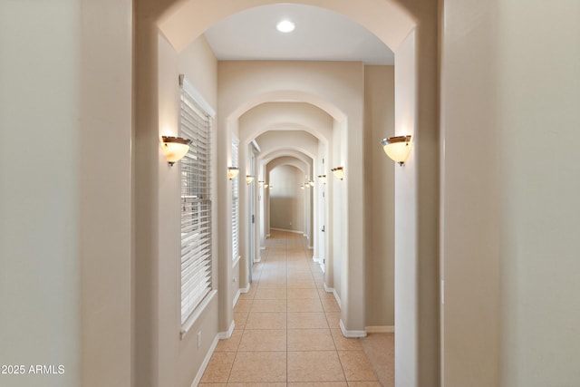 hallway with baseboards and light tile patterned flooring