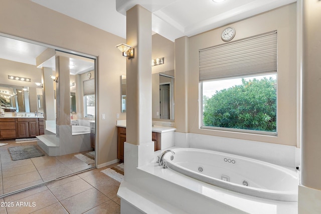 full bathroom featuring a sink, tile patterned flooring, a tub with jets, and two vanities