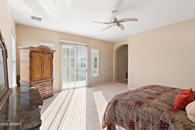 bedroom featuring arched walkways, light carpet, a ceiling fan, visible vents, and baseboards