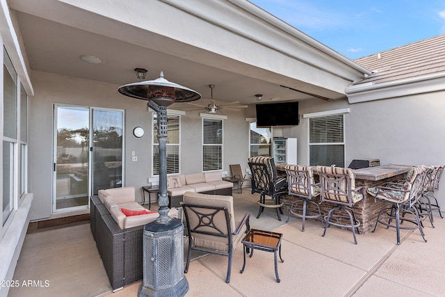 view of patio with outdoor dry bar, an outdoor living space, and a ceiling fan