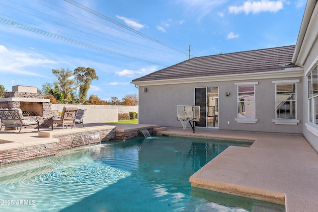 view of pool featuring an outdoor stone fireplace, a patio area, fence, and a fenced in pool