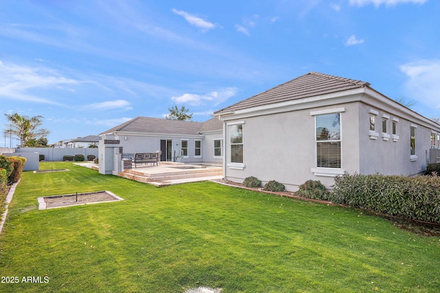 rear view of house featuring a yard, stucco siding, fence, a tiled roof, and a wooden deck