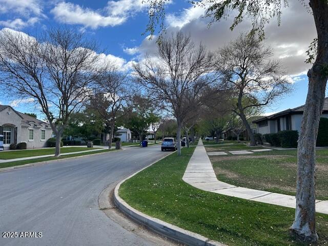 view of street with sidewalks, a residential view, and curbs