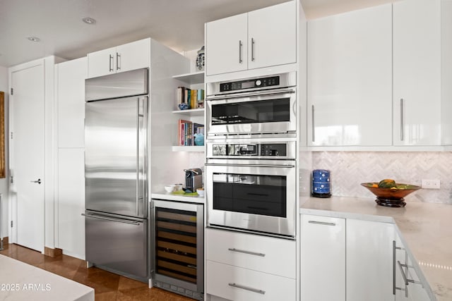 17 W Vernon Ave Unit 508, Phoenix, AZ 85003 - kitchen with appliances with stainless steel finishes, wine cooler, white cabinetry, and decorative backsplash