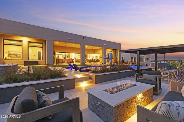 17245 E Desert Vista Trl, Rio Verde, AZ 85263 - patio terrace at dusk with a patio area, an outdoor living space with a fire pit, and a swimming pool