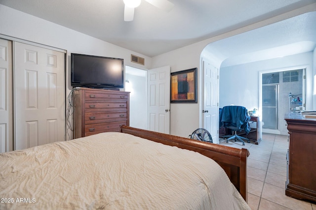 bedroom featuring ceiling fan, a closet, and light tile patterned floors