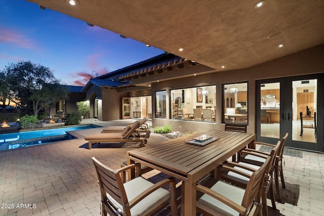 patio terrace at dusk featuring french doors