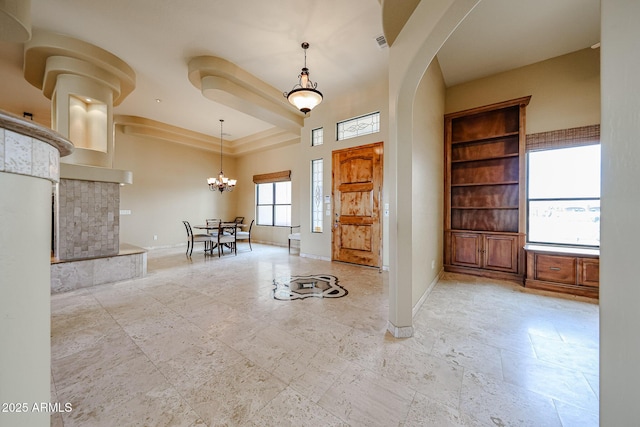 entryway featuring a tray ceiling and a chandelier