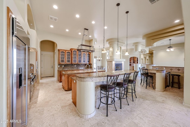 kitchen featuring pendant lighting, ceiling fan, a breakfast bar, and a spacious island