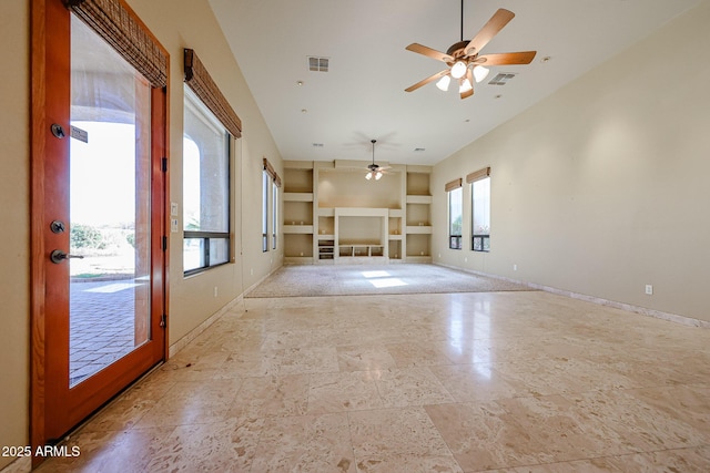 unfurnished living room with built in shelves and ceiling fan