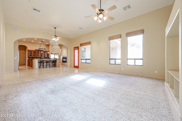 unfurnished living room featuring ceiling fan and light carpet