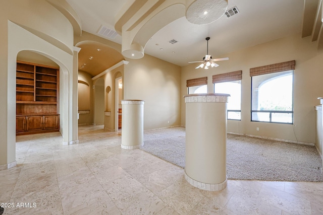 unfurnished room featuring ceiling fan and built in features