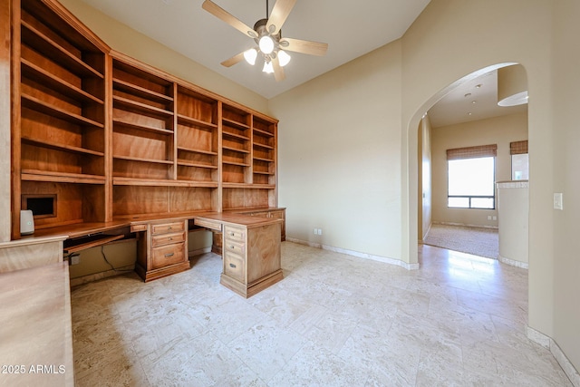 unfurnished office featuring high vaulted ceiling, built in desk, and ceiling fan