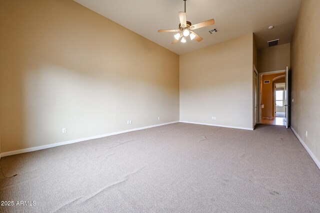 empty room with high vaulted ceiling, carpet flooring, and ceiling fan