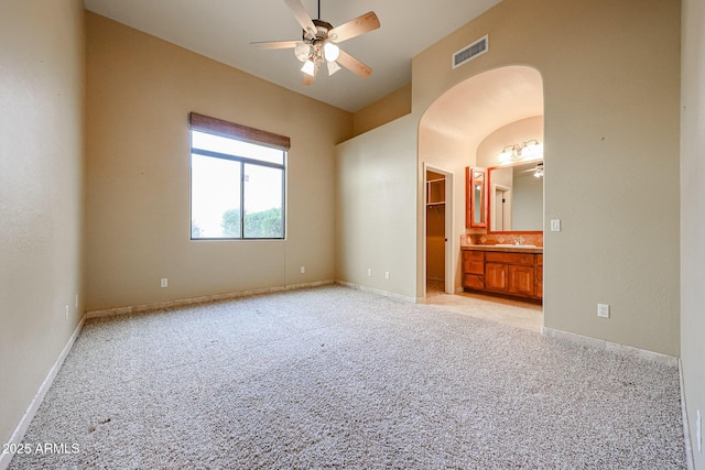 carpeted spare room featuring sink and ceiling fan