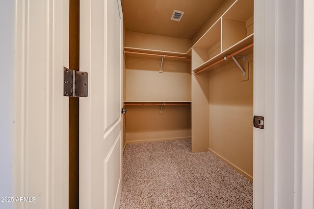 walk in closet featuring light colored carpet