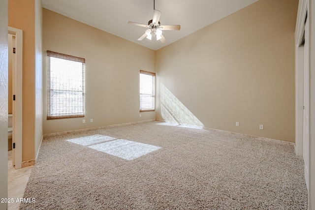 carpeted spare room with ceiling fan and lofted ceiling