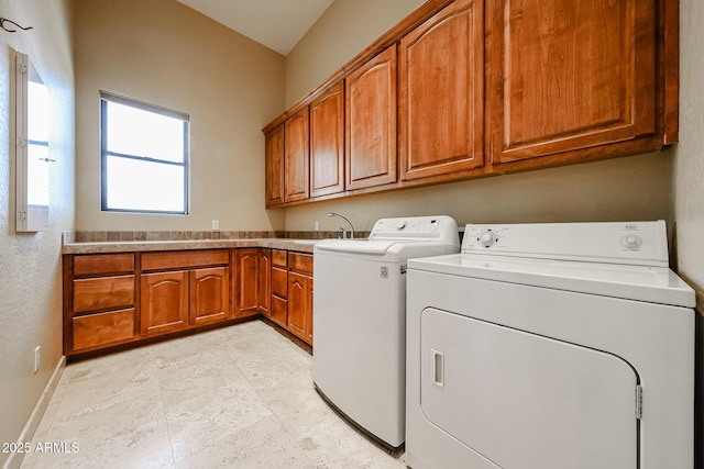 clothes washing area featuring cabinets, washer and dryer, and sink