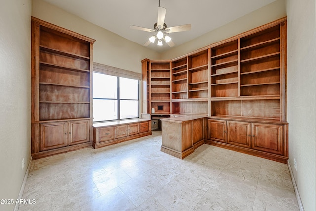 unfurnished office featuring built in desk and ceiling fan