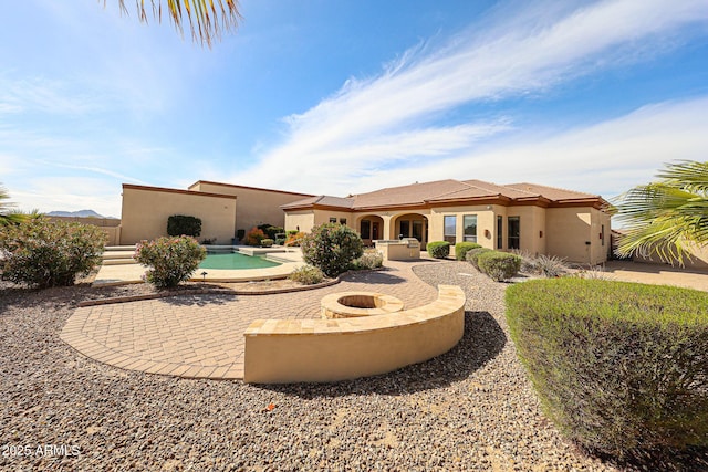 rear view of house featuring an outdoor fire pit and a patio area