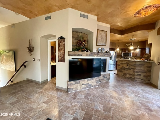 unfurnished living room with light stone finish floors and baseboards