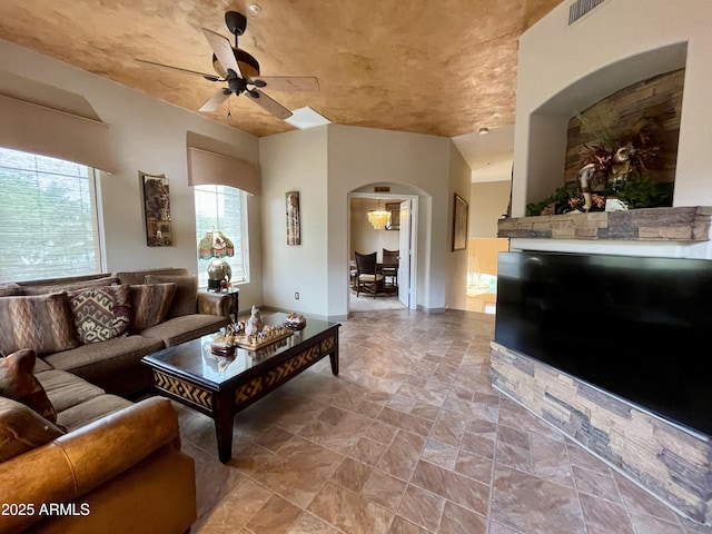 living area with ceiling fan and arched walkways
