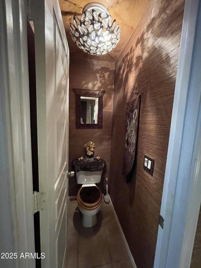 bathroom featuring toilet, tile patterned flooring, and baseboards