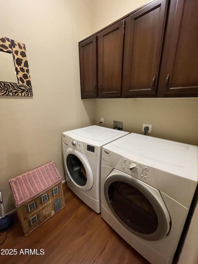 washroom with cabinet space, dark wood finished floors, and washing machine and clothes dryer