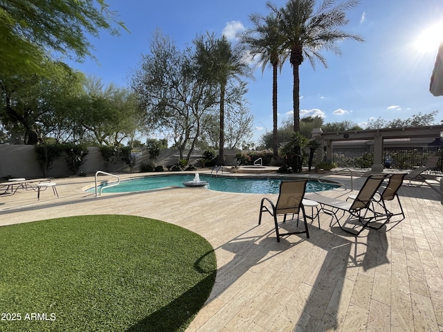 community pool with fence and a patio area