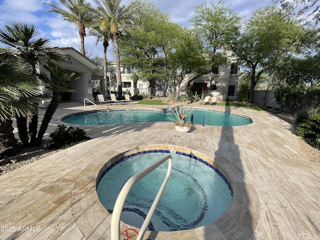 community pool featuring a community hot tub, a patio, and fence