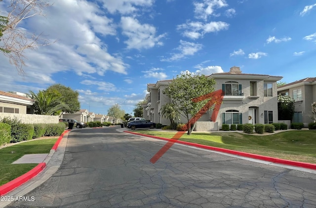 view of asphalt road featuring curbs and a residential view