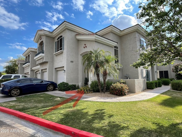view of front facade featuring stucco siding, a garage, and a front yard