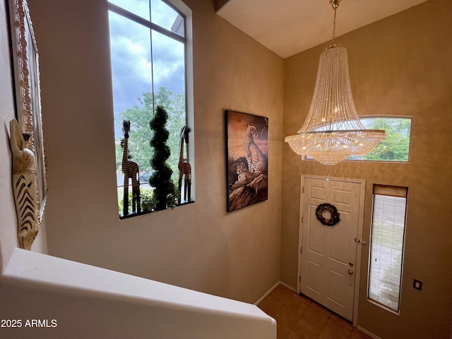 foyer entrance featuring a chandelier and baseboards