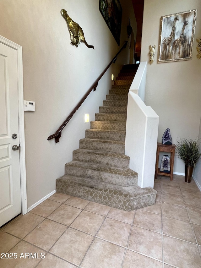 staircase with tile patterned floors and baseboards