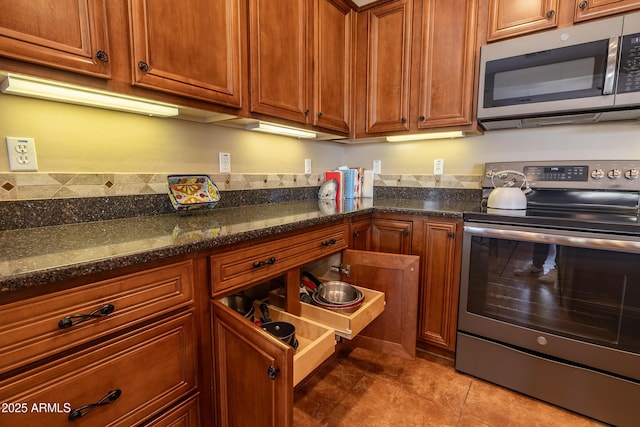 13050 W Pinnacle Vista Dr, Peoria, AZ 85383 - kitchen featuring appliances with stainless steel finishes, dark stone countertops, and light tile patterned floors