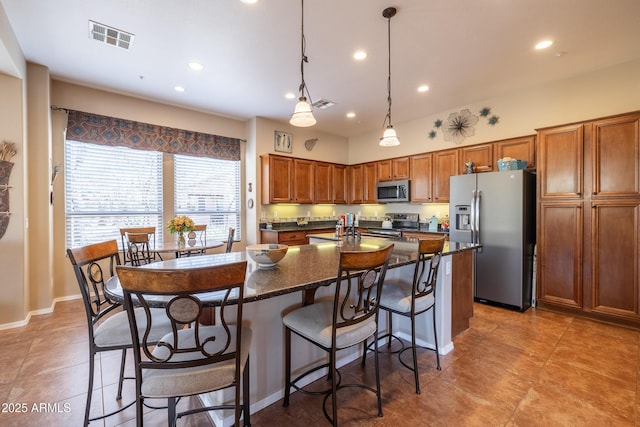 13050 W Pinnacle Vista Dr, Peoria, AZ 85383 - kitchen with pendant lighting, a center island with sink, stainless steel appliances, a kitchen bar, and dark stone counters