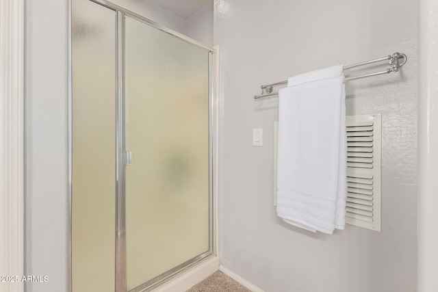 full bath with a shower stall and baseboards