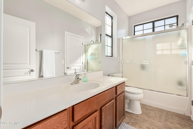 full bath with shower / bath combination with glass door, vanity, toilet, and tile patterned floors