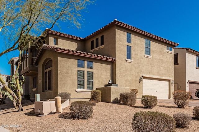 view of side of property with a garage, a balcony, and stucco siding