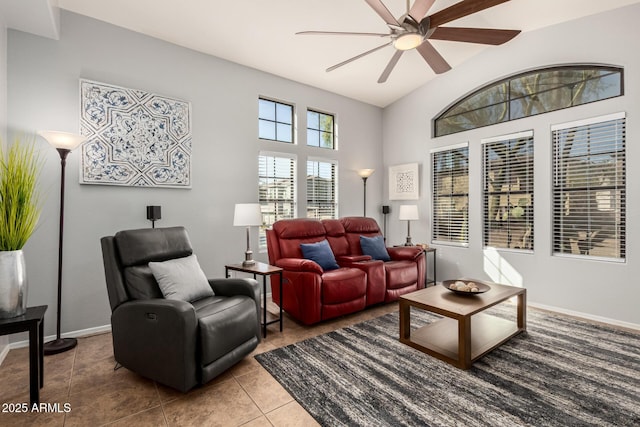 tiled living room with a ceiling fan and baseboards