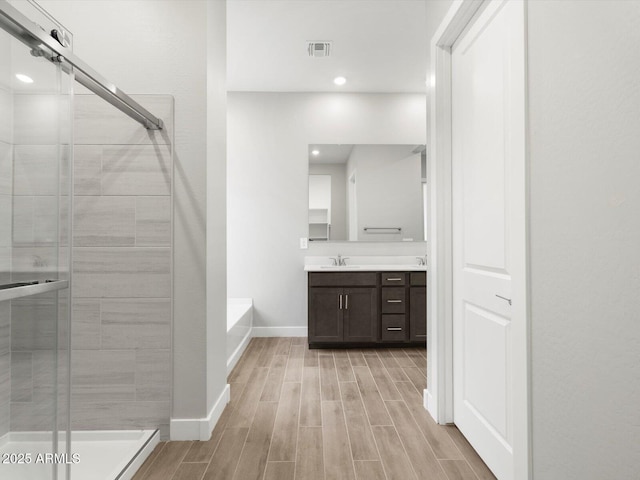 17621 W Pierson St, Goodyear, AZ 85395 - bathroom with vanity, baseboards, a stall shower, wood finished floors, and recessed lighting