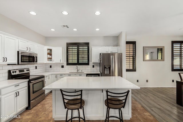 9350 W Williams St, Tolleson, AZ 85353 - kitchen featuring stainless steel appliances, a kitchen island, a breakfast bar area, healthy amount of natural light, and recessed lighting