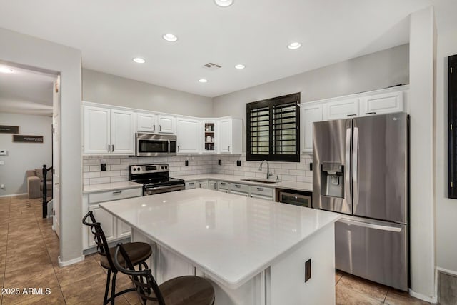 9350 W Williams St, Tolleson, AZ 85353 - kitchen with stainless steel appliances, decorative backsplash, white cabinetry, a center island, and recessed lighting