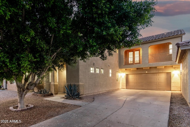 9350 W Williams St, Tolleson, AZ 85353 - view of front of property with driveway, a garage, stucco siding, a balcony, and a tile roof