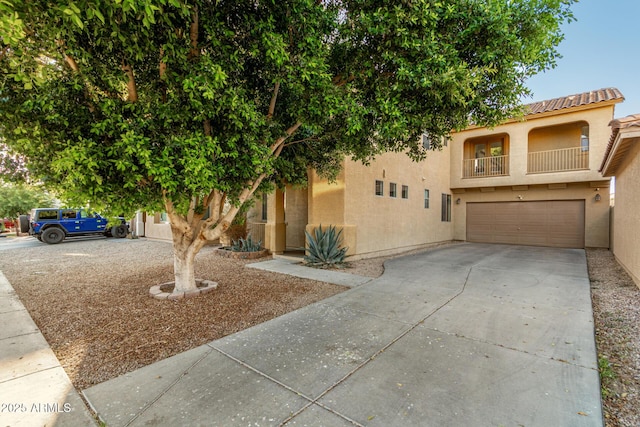 9350 W Williams St, Tolleson, AZ 85353 - view of front facade featuring a garage, stucco siding, concrete driveway, a tile roof, and a balcony