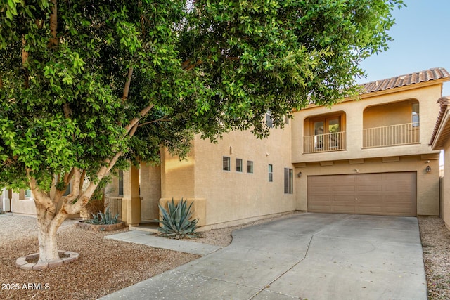 9350 W Williams St, Tolleson, AZ 85353 - view of front of house featuring a garage, concrete driveway, stucco siding, a balcony, and a tiled roof
